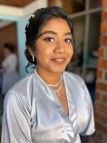 A pre-gown shot of Anu, showing her makeup and hair. The braided detail in her bun adds a touch of elegance.