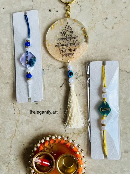 A Rakshabandhan hamper featuring a Gayatri Mantra hanging, custom Rakhis, and a small thali.