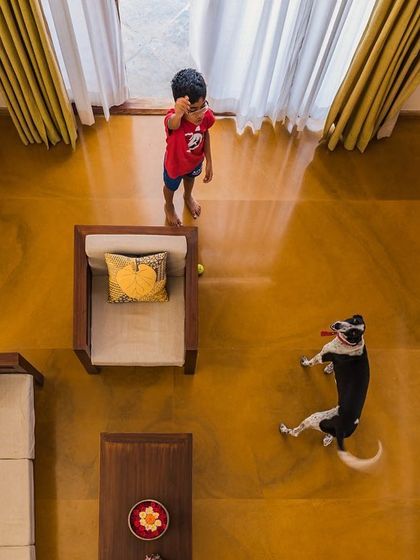 A top-down view of the living space, capturing a moment of life with a child and their dog. For us, a home is truly complete when it is filled with joy and activity.