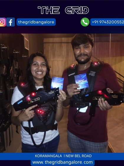 A couple proudly displays their laser tag score cards.