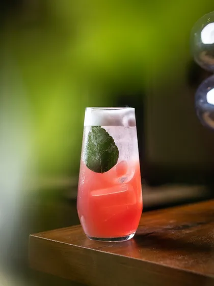 The Ms. Monroe mocktail, a sophisticated blend of litchi, raspberry, lime, and kaffir leaf, topped with a vegan foam. It’s a complex and refreshing non-alcoholic creation.