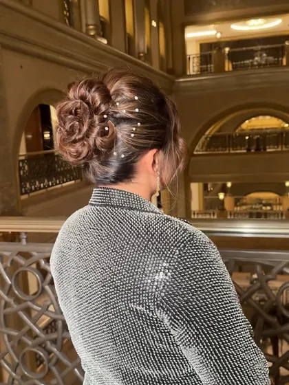 An intricate, twisted texture bun adorned with delicate rhinestones. This hairstyle is perfect for an evening event that calls for understated opulence.