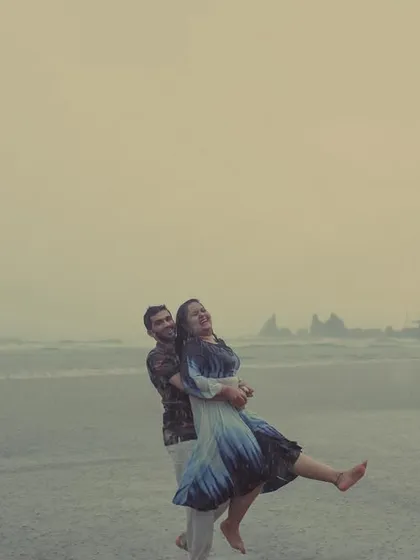 A couple joyfully embraces the Goan monsoon, dancing barefoot on the wet sand. We believe the best moments are unscripted, and our rainy pre-wedding shoots are perfect for capturing that spontaneous, carefree love.