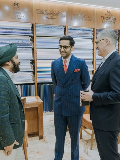 Our showroom, with its extensive library of fabrics, served as the perfect backdrop for hosting the delegation from Scabal. Here, our director is seen in conversation, wearing a custom-made pinstripe suit.