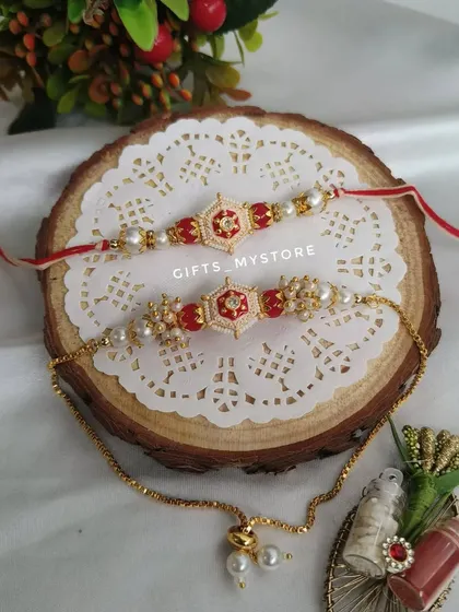 A classic red and gold couple's Rakhi set, perfect for traditional Rakshabandhan celebrations.