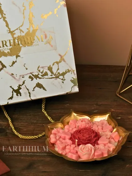 A lotus-shaped urli filled with a garden of pink and red roses. This piece is all about abundant beauty.