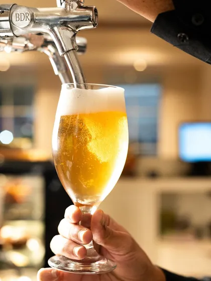 An action shot of beer being poured from the tap. The bubbles and flowing liquid add a dynamic element that makes the viewer thirsty.