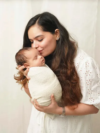 A mother kisses her sleeping baby's head. This simple, classic pose is one of the most powerful ways to show a mother's love.