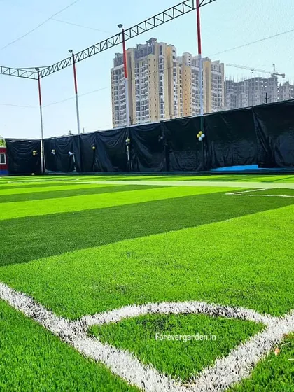 The corner of the sports field, showing the clean white lines and the even, lush texture of the artificial grass.