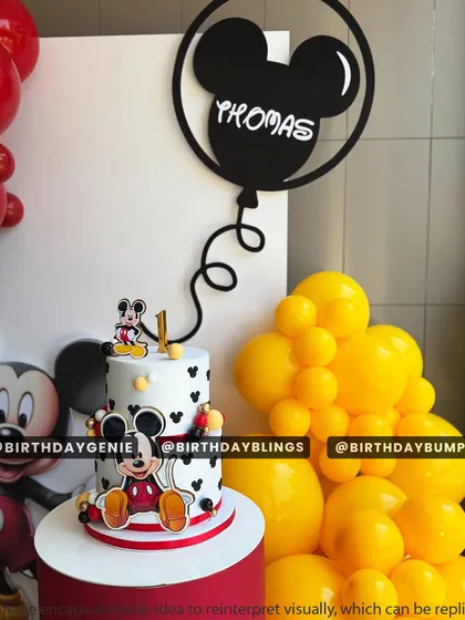 A close-up of the adorable, two-tiered Mickey Mouse cake, perfectly matching the party's theme.