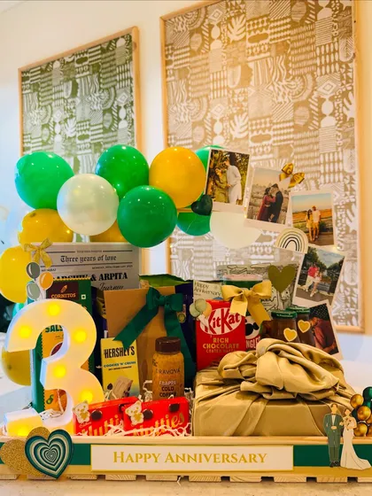 Celebrating a third anniversary with a story told in emerald and gold. This hamper features a custom newspaper detailing the couple's journey, their favorite treats, and personal photos, making it a truly unique and sentimental milestone gift.