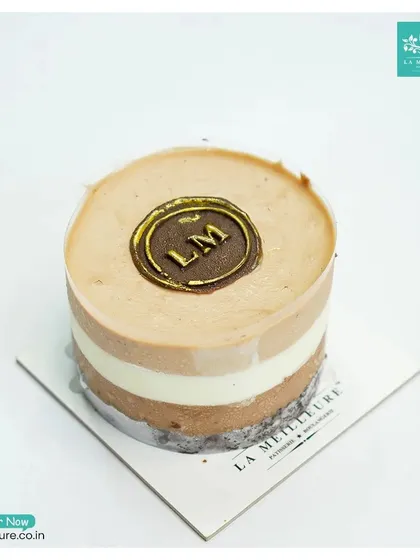 Our Trio Mousse pastry is a delight for the senses. It features three distinct layers of chocolate and vanilla mousse on a biscuit base, finished with our golden 'LM' seal.