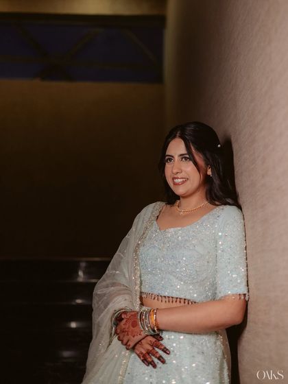 A professionally shot portrait, her leaning against the wall, looking serene and beautiful.