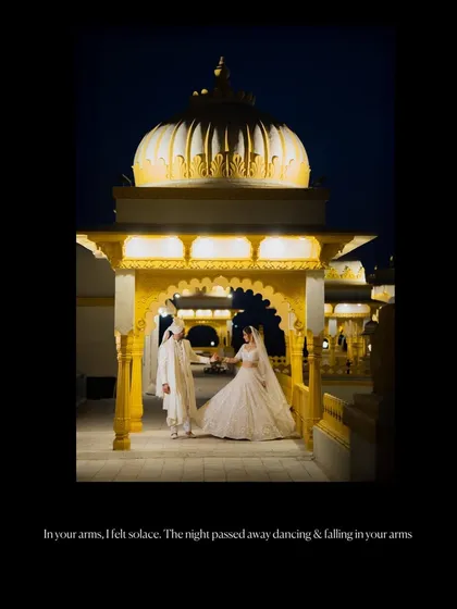 A dramatic nighttime portrait of a couple under an illuminated heritage dome.