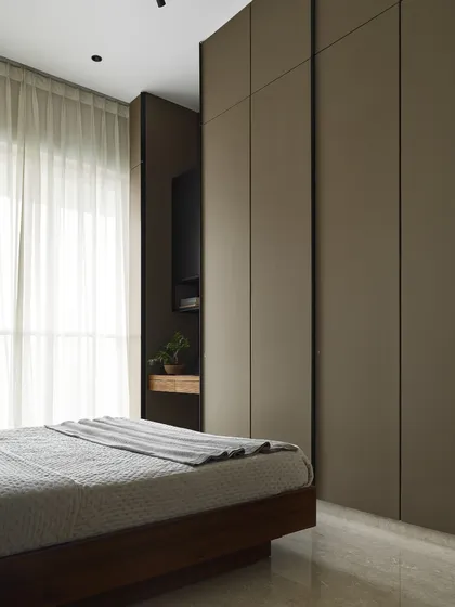 The wardrobes in the Taupe Bedroom are designed with a minimalist aesthetic, featuring clean lines and a neutral taupe finish. The floor-to-ceiling construction maximizes storage and helps the units blend into the wall, enhancing the room's spacious feel.