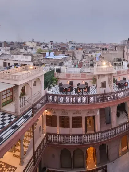 An expansive view of the Haveli Dharampura terrace, overlooking the dense urban fabric of Old Delhi. This space allows guests to engage in traditional activities like kite flying, connecting them with the living culture of the area.