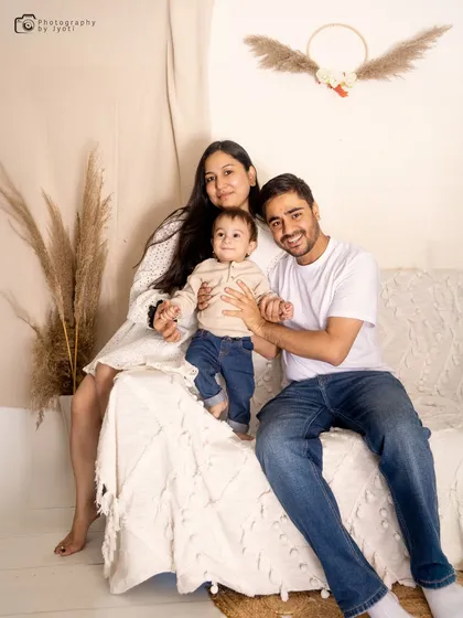 A relaxed family portrait on a comfortable sofa in a minimalist, boho-chic studio setting. This style is perfect for creating modern and authentic family photos.
