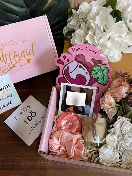 This complete bridesmaid box, priced at ₹700, includes a 'Will you be my Bridesmaid?' card, a custom polaroid, a scented candle, hair accessories, and a face mask, all beautifully arranged.