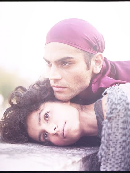 A soft, romantic portrait of a male and female model from an archival shoot. The film grain and warm tones give the image a nostalgic and timeless quality.