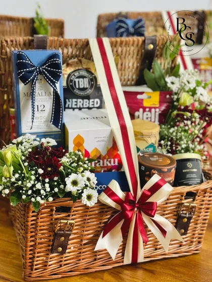 A truly luxurious gift experience. This large wicker hamper is filled with premium items, including a bottle of Macallan 12, gourmet coffee, and fresh flowers, making it an exceptional gift for a connoisseur.