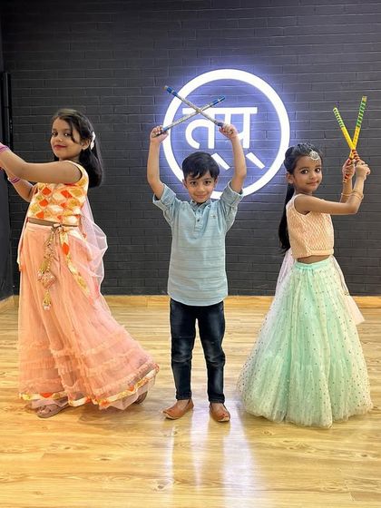 A trio from my kids' dandiya class posing with their sticks. I teach both boys and girls, making it a fun activity for everyone.