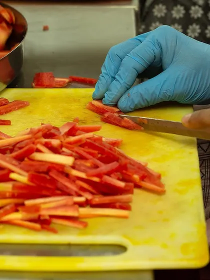 Precision in every cut. Our team hand-cuts carrots into fine strips for our Carrot Chilli Pickle, ensuring the perfect texture in every jar.