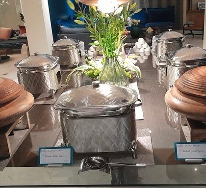 A bespoke catering experience in the comfort of a client's home, featuring a mix of traditional wooden and modern silver serveware.