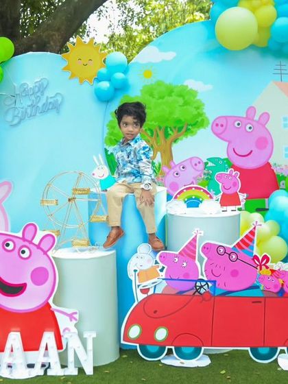 A fun-filled Peppa Pig party in an outdoor setting. We created a vibrant scene with character cutouts, a custom backdrop of Peppa's house, and a large light-up number '2' for the birthday boy's special day.