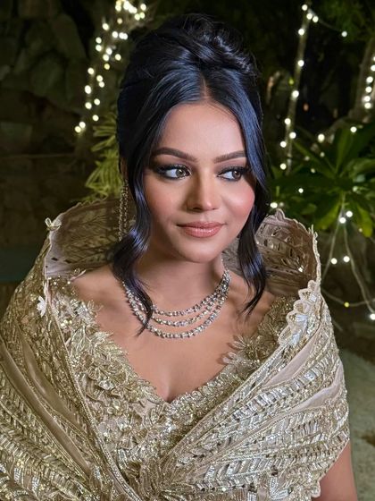 A different angle of the high bun with face-framing tendrils, showing its structure and shine under the lights.