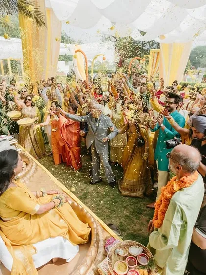 A beautiful moment of celebration during a Haldi ceremony. As the wedding games MC, I orchestrate these moments of collective joy, like this flower shower, to create picture-perfect memories.