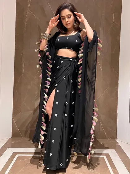 Here’s a boho-chic look I put together for Nushrratt Bharuccha. This black draped outfit with a thigh-high slit and tassel details is a great example of fusion wear that is both edgy and glamorous, perfect for a stylish evening event.