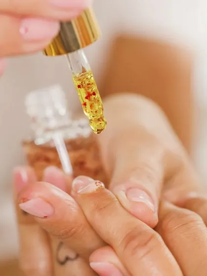 We believe in using nourishing treatments for lasting nail health. Here, a client's cuticles are being treated with our signature Moroccan oil, a service that adds deep hydration and a natural glow.