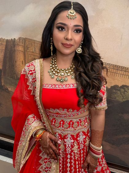 A front view of the bride with her half-updo, showing how the style frames her face and complements her smoky eye makeup.