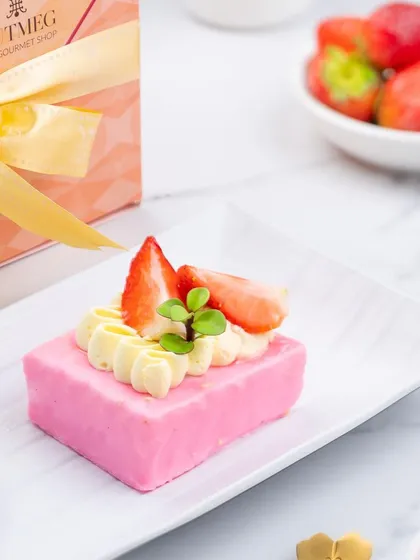 A dessert shoot for a gourmet shop, featuring a delicate strawberry pastry. The styling is clean and bright, with a marble background and fresh strawberries to emphasize the quality and craftsmanship of the dessert.