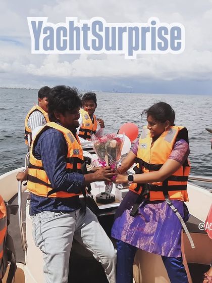 A family celebrating a special occasion with a surprise bouquet on a yacht.