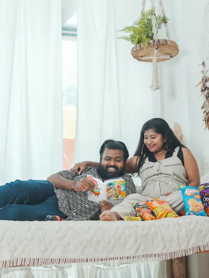 A relaxed, lifestyle maternity shoot at home or in a studio, just chilling with snacks. It’s a fun way to show your real life together.