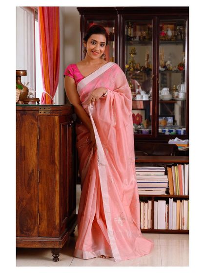 A full-length shot that captures the simple elegance of the pink linen saree.