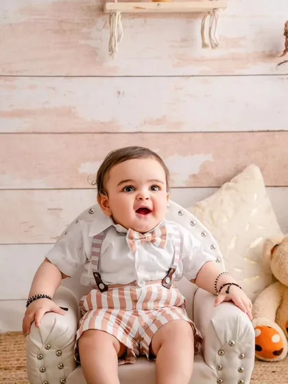 A little prince with a big personality. This baby boy looks so charming and happy in his little armchair.