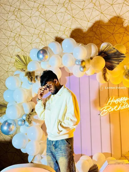 The birthday boy posing in front of his modern and stylish party decor.