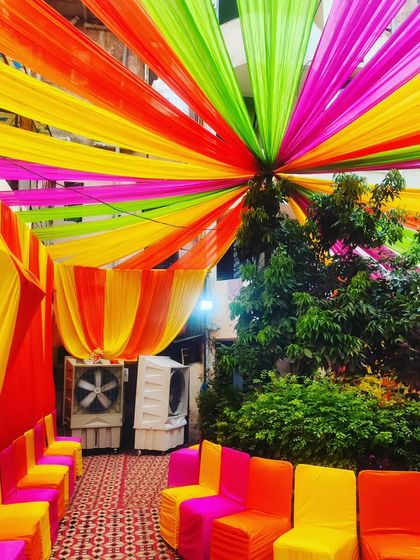 The seating area under the colourful canopy, showing how even a simple outdoor space can become a comfortable and festive venue.