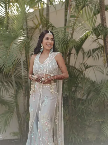 The gorgeous bride looking radiant before her Haldi ceremony, dressed in a stunning outfit and floral jewelry.