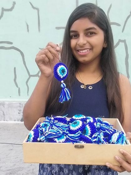 Holding up one of the evil eye keychains from my first bulk order. Such a proud moment.