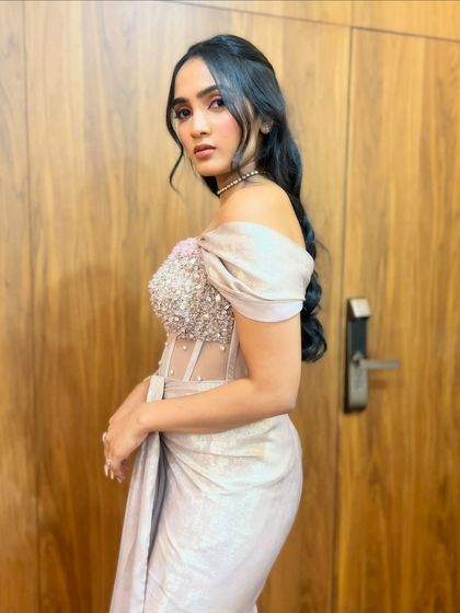 A client with soft, open waves and a delicate pink ribbon, a sweet and romantic look.