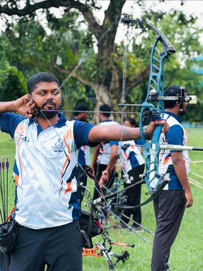 A front-facing view of my shooting stance with a compound bow during a practice session. Maintaining alignment and focus is critical, even with other archers on the line.