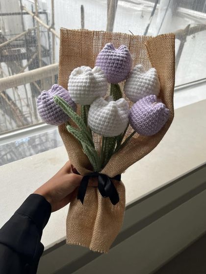 Simple, clean, and elegant. This bouquet features our classic closed tulips in alternating lavender and white, wrapped in rustic burlap with a simple black ribbon.