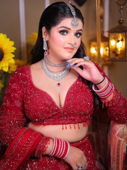 A confident portrait that showcases the intricate details of the blouse and jewelry.