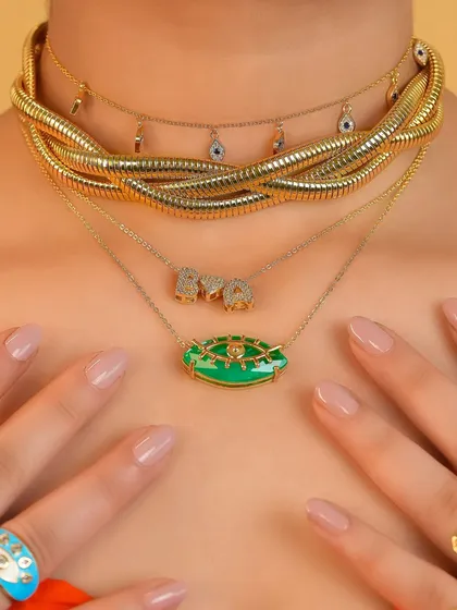 More is more and we are here for it. This is how we love to see our necklaces styled, with bold layers of gold, vibrant green evil eye pendants, and personalized initial charms creating a look that's impossible to ignore.