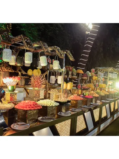 A vibrant and colorful chaat and fruit counter, beautifully arranged with a variety of snacks, fruits, and decorative lanterns.