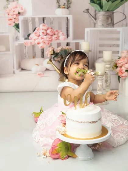A mouthful of happiness. This close-up captures the pure joy of a baby tasting her first birthday cake, a memory her parents will cherish forever.