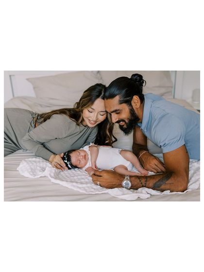 A candid moment on the bed with new parents and their baby. These relaxed, lifestyle photos are all about capturing your family's authentic connection.